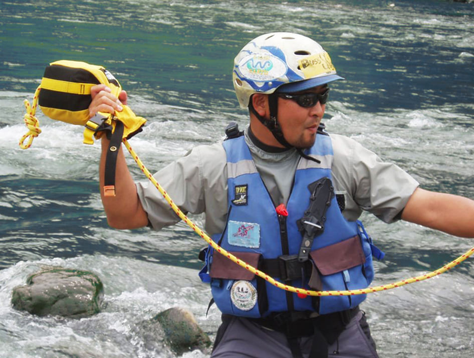 川でロープを構えるレスキュー隊員