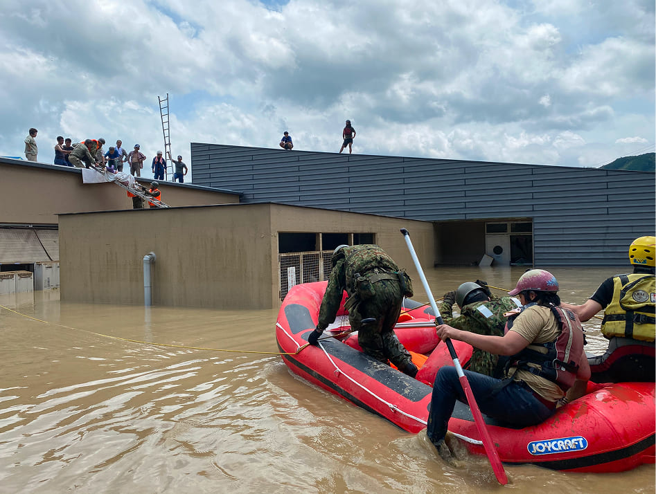 屋根から救助するスタッフ