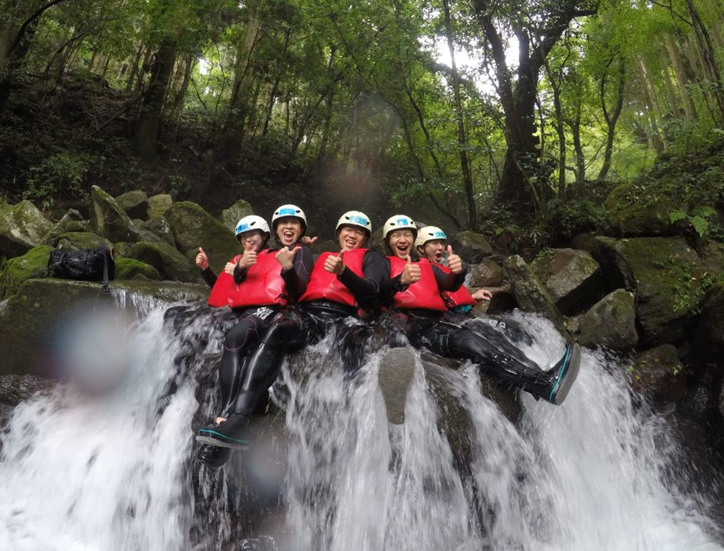 滝の上流でポーズする男女